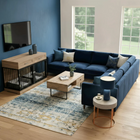 OnePaw ELARA modern living room with a blue sectional sofa, wooden coffee table, and a pet crate.