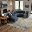 OnePaw AURELIA blue sectional sofa in a living room with a fireplace and a wooden pet crate.