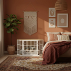 OnePaw EIRENE dog crate in a bedroom with a bed, pillows, and decorative wall art.