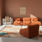 OnePaw EIRENE brown sectional sofa in a living room with a patterned rug and a pet crate.