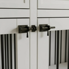 Close-up of white pet crate doors with black handles
