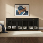 Black crate with white bedding in a room with a beige wall and framed artwork