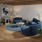 OnePaw LYRA modern living room with blue sectional sofa, round coffee table, and wooden pet crate.