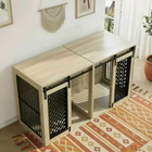 Wooden pet crate with sliding black metal doors in a room with a rug and window.