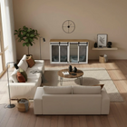 Modern living room with white sofas, a coffee table, and wooden pet crate