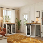 Living room with two white pet crates with black metal grates on a yellow patterned rug.