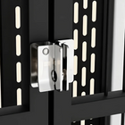 Close-up of a metallic door handle on a black door with geometric patterns.