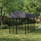 Dog kennel with a gray cover in a grassy area with trees