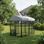 Large black metal dog kennel with a white roof in a backyard setting.