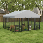 Large outdoor dog kennel with a gray roof in a backyard setting.