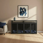 Modern living room with a black pet crate, gray sofa, and abstract art on the wall.