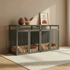 Pet crate with bedding inside, placed on a wooden floor with a rug and decorative items in the background.