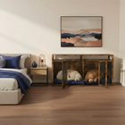 Two dogs in a wooden crate inside a bedroom with a bed and nightstand.