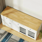 Wooden furniture style pet crate with white base and black metal grilles on a wooden floor.