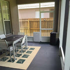 Security Boss SB4 Pet Screen Door with table and chairs in a home interior, looking out to a backyard.