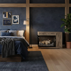 OnePaw SELENE dog in a wooden crate inside a bedroom with a bed, lamp, and wall art.