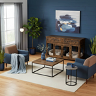 OnePaw THEIA modern living room with blue walls, wooden pet crate, and decorative plants.